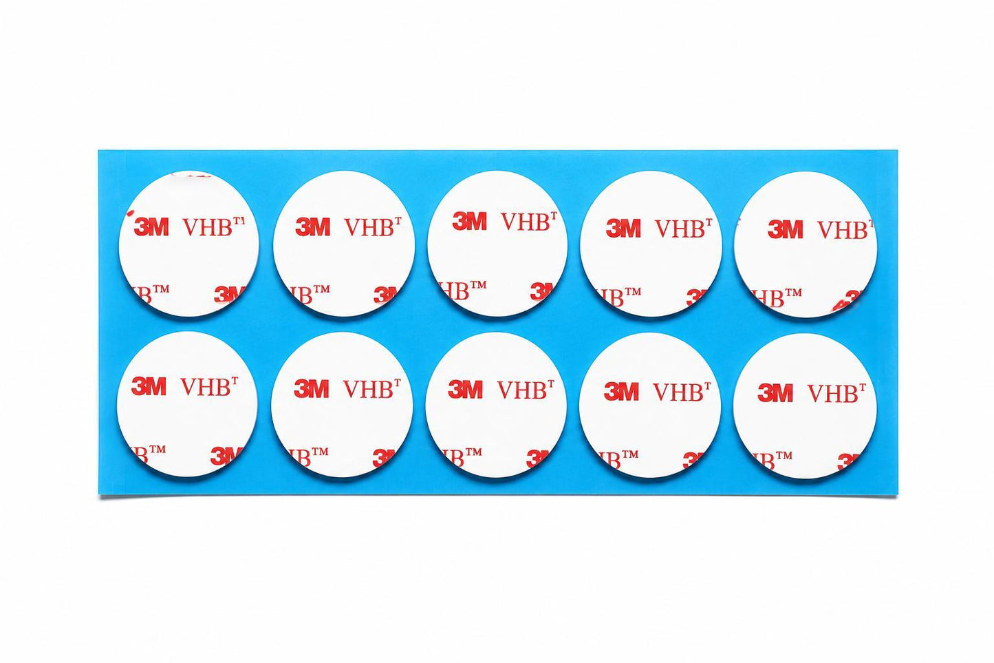 Genuine 3M VHB 4910 clear round double sided sticky pads on a blue backing sheet with white 3M VHB liner. Strong crystal clear acrylic foam adhesive for invisible mounting applications.
