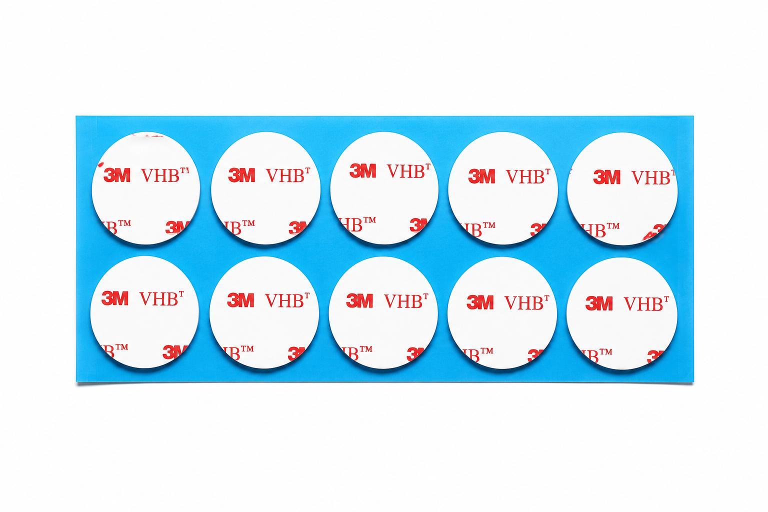 Genuine 3M VHB 4910 clear round double sided sticky pads on a blue backing sheet with white 3M VHB liner. Strong crystal clear acrylic foam adhesive for invisible mounting applications.